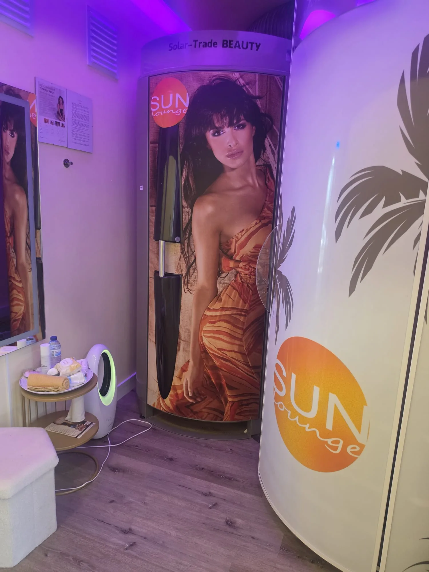 Cabine de solário vertical com iluminação violeta e mesa de produtos